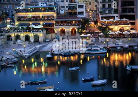 Restaurants and harbour at night Spinola Bay St Julian s Malta Stock Photo