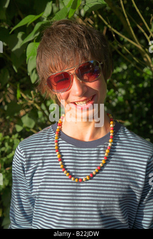Hippy boy portrait smiling wearing shades and necklace Stock Photo