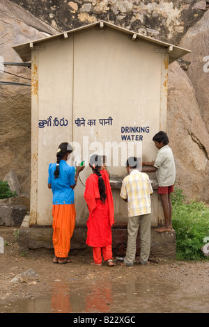 Children take a drink of water in Hyderabad, India. They are a drinking water stand. Stock Photo