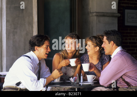 Two young couples talking to each other in cafe Stock Photo