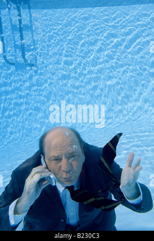 Businessman using mobile phone in swimming pool elevated view Stock Photo