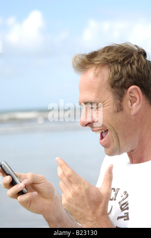 Close-up of man using mobile phone on beach Stock Photo