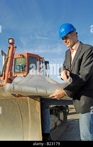 Male architect looking at blueprints Stock Photo