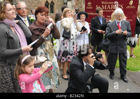 Family and friends gather to photograph a newly married couple Stock Photo