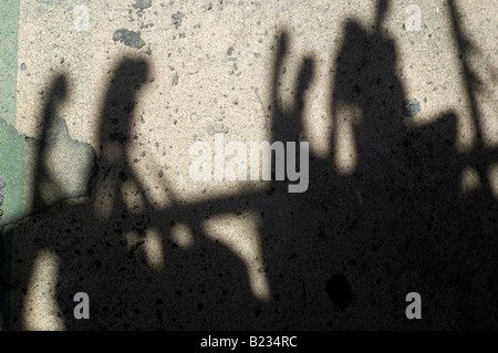 Shadows of clothes hangers on conglomerate concrete Stock Photo