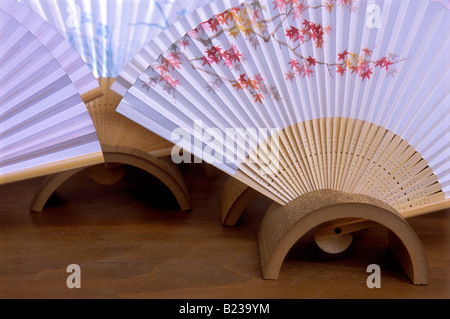 Display of artistically painted paper and bamboo folding fans in bamboo rests for the autumn season Stock Photo