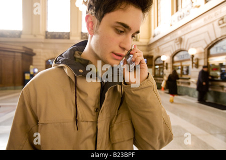 Young man using cell phone in a train station Stock Photo