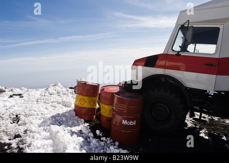 Gasoline barrels near a Mercedes shuttle bus on Mount Etna, Sicily, Italy Stock Photo