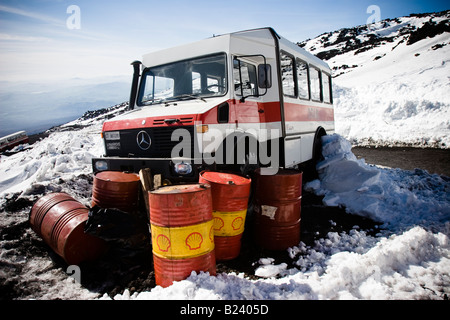 Gasoline barrels near a Mercedes shuttle bus on Mount Etna, Sicily, Italy Stock Photo