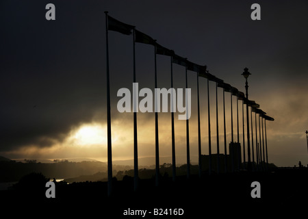 City of Plymouth, England. Sunset view of UN flags flying on Plymouth Hoe promenade, with Plymouth Sound in the background. Stock Photo