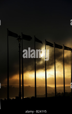 City of Plymouth, England. Sunset view of UN flags flying on Plymouth Hoe promenade, with Plymouth Sound in the background. Stock Photo