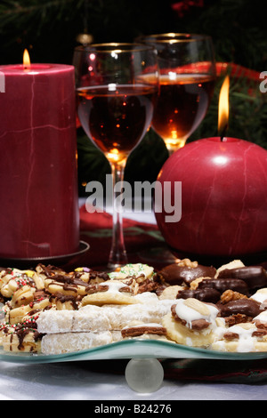 Christmas cookies on a plate and two glasses of wine with two burning candles blurred blurry background sweet food biscuits nobody front view hi-res Stock Photo