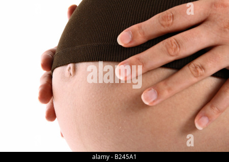 Belly of a pregnant woman with her hands on it Stock Photo