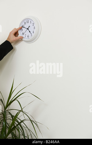 An office worker adjusting the hands on a clock Stock Photo