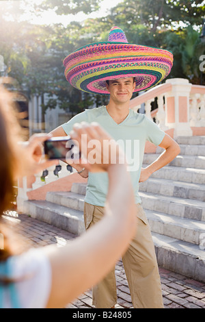 Woman photographing man wearing sombreros Stock Photo