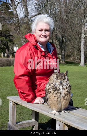 Senior citizen lady sitting next to Fonzy the Bengal Eagle Owl Stock Photo