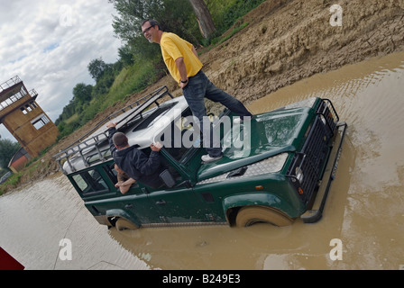 Standing on the bonnet and awaiting recovery for a Land Rover Defender stuck in a puddle while off roading in Bining, France. Stock Photo