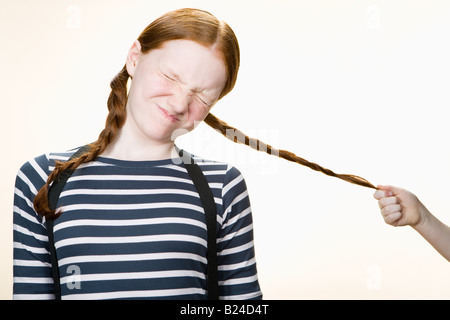 A girl having her pigtail pulled Stock Photo