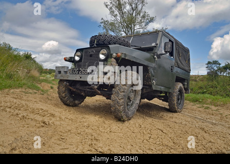 A 1960s Land Rover Lightweight Series 2a with headlamps in the radiator panel driving off road in Bining, France. Stock Photo