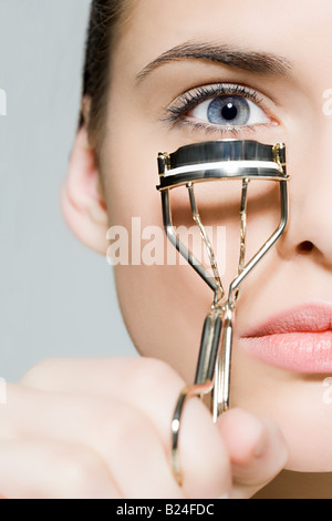 Woman with eyelash curler Stock Photo