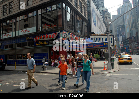 A group of tourists crosses the street in front of Ellen s Stardust Diner in Times Square Stock Photo