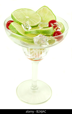 Margarita glass filled with sliced limes and cherries isolated on a white background Stock Photo