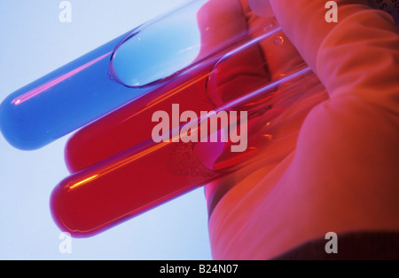 CLOSE UP GLOVED HAND HOLDING TEST TUBES Stock Photo