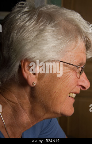Stock photo of a seventy year old woman wearing her hearing aid Stock Photo