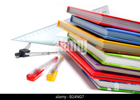 Pens, compass, rulers and pile of colorful books isolated on white Stock Photo