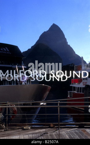 Mitre Peak, Milford Sound, Fiordland, New Zealand, viewed through glass windows of cruise ship terminal, cruise ships foreground Stock Photo