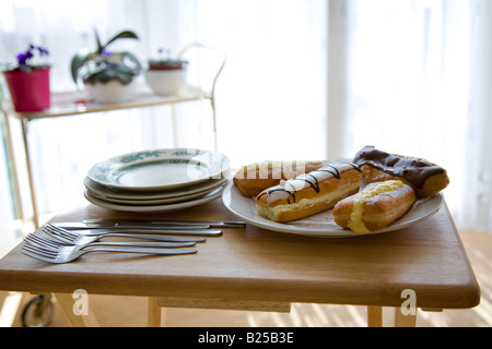 a plate of cream cakes from Tesco in the UK arranged on a plate in a style befitting an elderly lady's home Stock Photo