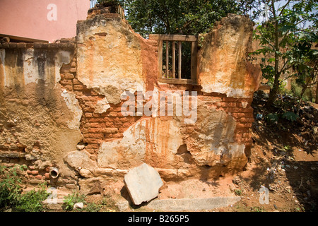 The wall of a delapidated house in Bangalore, India. The plaster has crumbled and bricks are exposed. Stock Photo