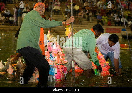 A man dips Ganesha idols into the tank at Lank Ulsoor in Bangalore, India. This is part of the Ganesh Churti celebrations. Stock Photo