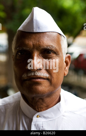 An Indian man wears a traditional Nehru hat. The hat when worn with