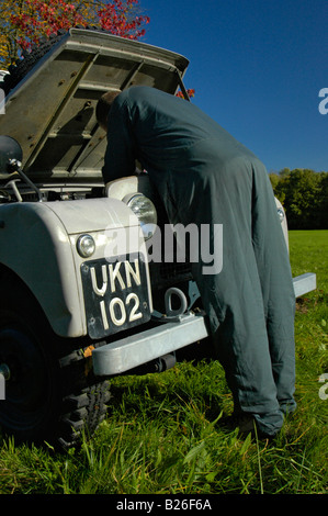 Mechanic checking the engine on a grey 1950's Land Rover Series One 86 inch Station Wagon. Stock Photo