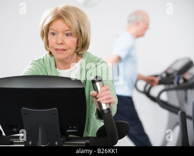 Senior woman on exercise machine Stock Photo