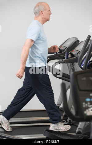 Senior man walking on treadmill Stock Photo