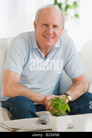 Senior man sitting on sofa Stock Photo
