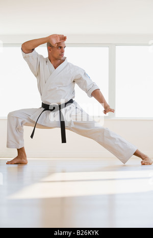 Hispanic male karate black belt in fighting stance Stock Photo