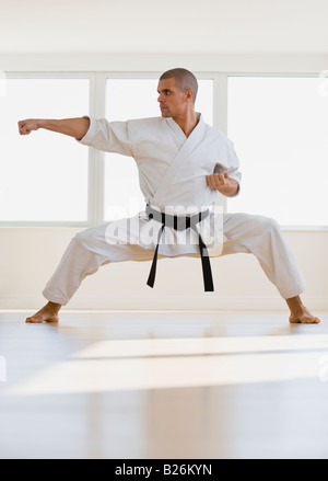 Hispanic male karate black belt in fighting stance Stock Photo
