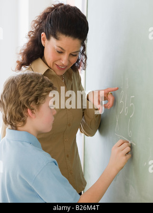 Hispanic teacher helping student with math problem Stock Photo
