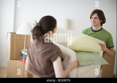 Couple carrying bedding in new house Stock Photo