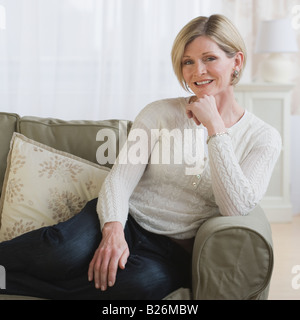 Woman sitting on sofa Stock Photo