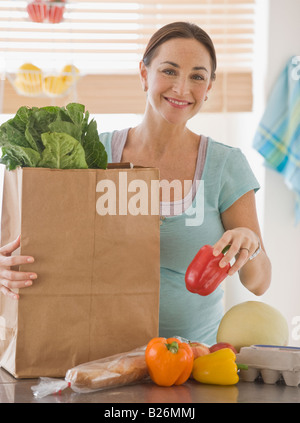 Pregnant Hispanic woman unpacking groceries Stock Photo