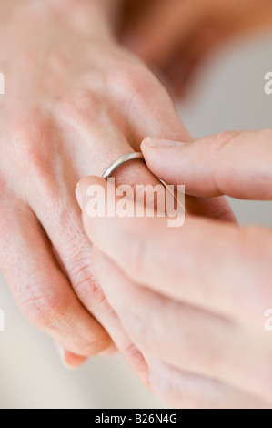 Man putting wedding ring on woman’s finger Stock Photo