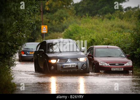 CARS NEGOTIATE FLOODWATER IN A RESIDENTIAL STREET DURING THE FLOODS IN GLOUCESTERSHIRE JULY 2007 UK VEHICLES WITH LOW AIR INTAKE Stock Photo