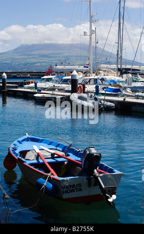 A small dinghy tied to the harbor wall in Horta on the Island of Faial Stock Photo