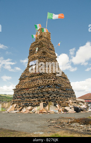 Large bonfire in Mossley, Newtownabbey, Northern Ireland, with Irish Tricolour flags and Celtic shirts Stock Photo