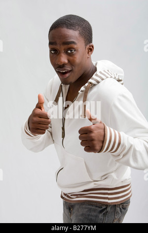 Dark skinned handsome young man stylish wearing a white hooded shirt Everything is okay two thumbs up Isolated Stock Photo