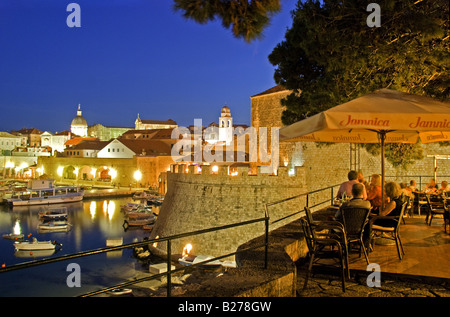 Dubrovnik Old Town, outdoor cafe near Ploce Gate overlooking Old Port's harbour in evening Stock Photo